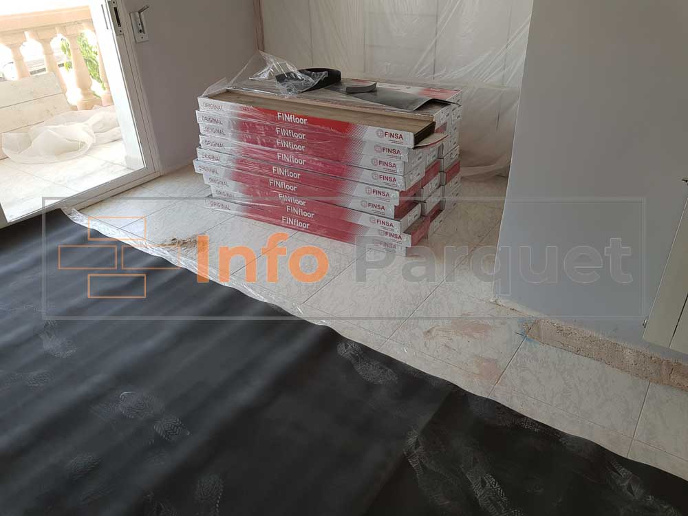 Una habitación con suelo negro y una gran pila de cajas.
