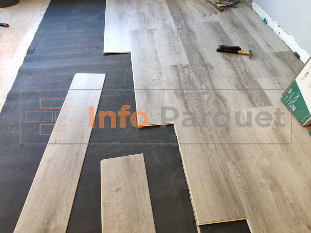 Una habitación con suelo de madera y herramientas siendo instaladas.