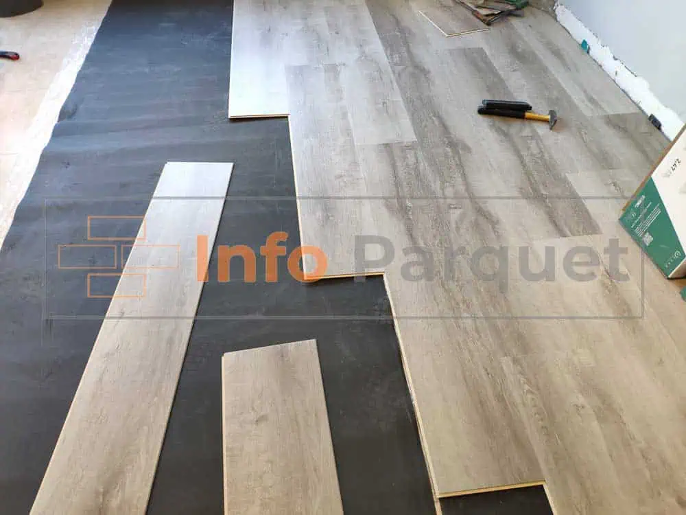 Una habitación con suelo de madera y herramientas siendo instaladas.